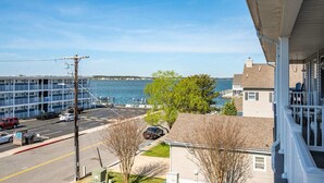 A coastal view with a parking lot, a multi-story building, and a house with a dock. - Clammers Cove 4 (Ocean City)