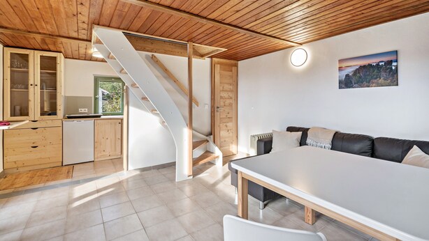 A modern interior with a wooden ceiling, a staircase, a dining area, and a kitchen. - Cozy Kirschallee Cottage with Mountain View, Private Terrace & Shared Garden (Hohnstein)
