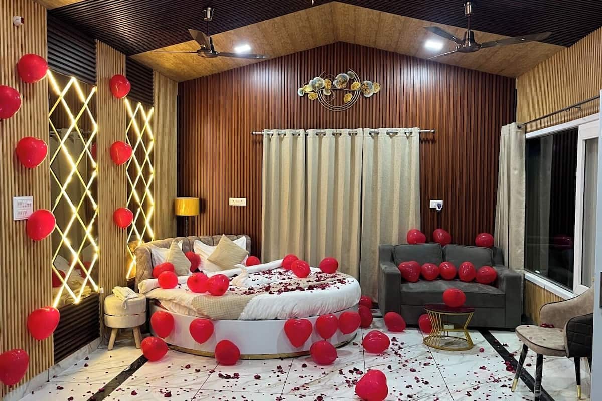 A bedroom with a bed, a sofa, and a window.