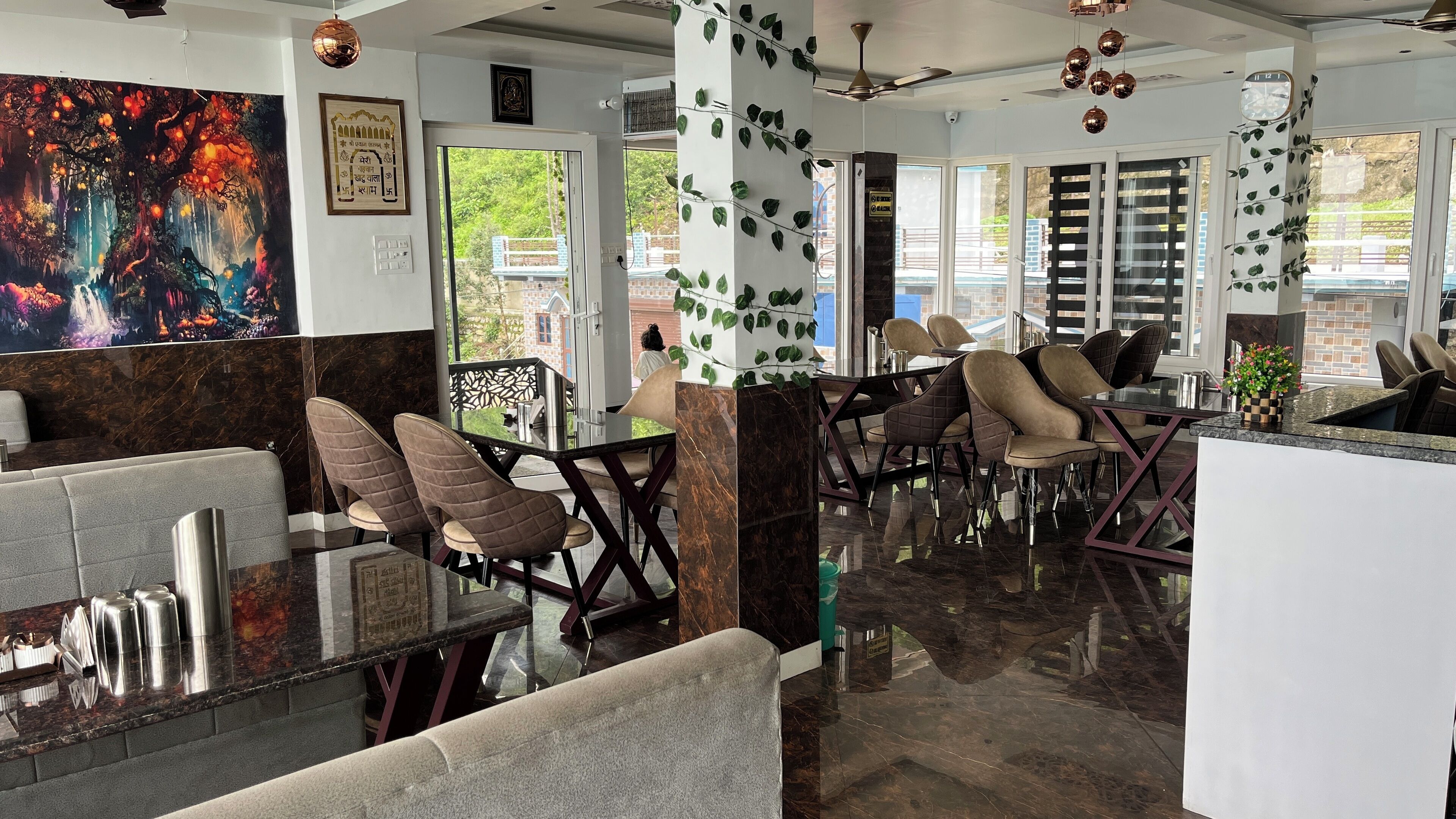 A modern restaurant with marble flooring, cushioned chairs, and a large mural on the wall.
