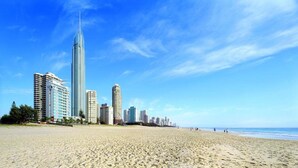 Uma praia com edifícios altos ao fundo.