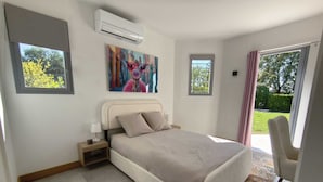 Ein Schlafzimmer mit Bett, Nachttisch, Klimaanlage und einem Bild an der Wand.