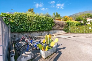 A parking area with bicycles, a cactus plant, and a clear sky. - Bogliaco Lake Front (Gargnano)