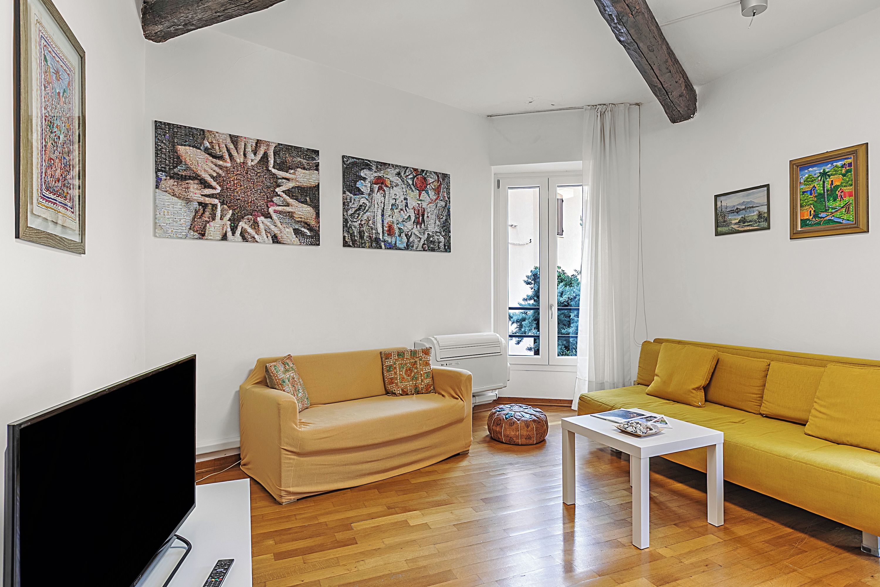 Un salon avec un canapé, une table basse et un téléviseur à écran plat.