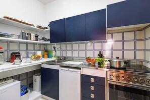 A modern kitchen with blue cabinets, a stainless steel stove, and a dishwasher. - Bogliaco Lake Front (Gargnano)
