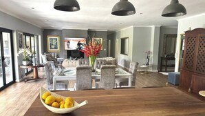 A spacious living room with a large wooden coffee table, a television, and comfortable seating.