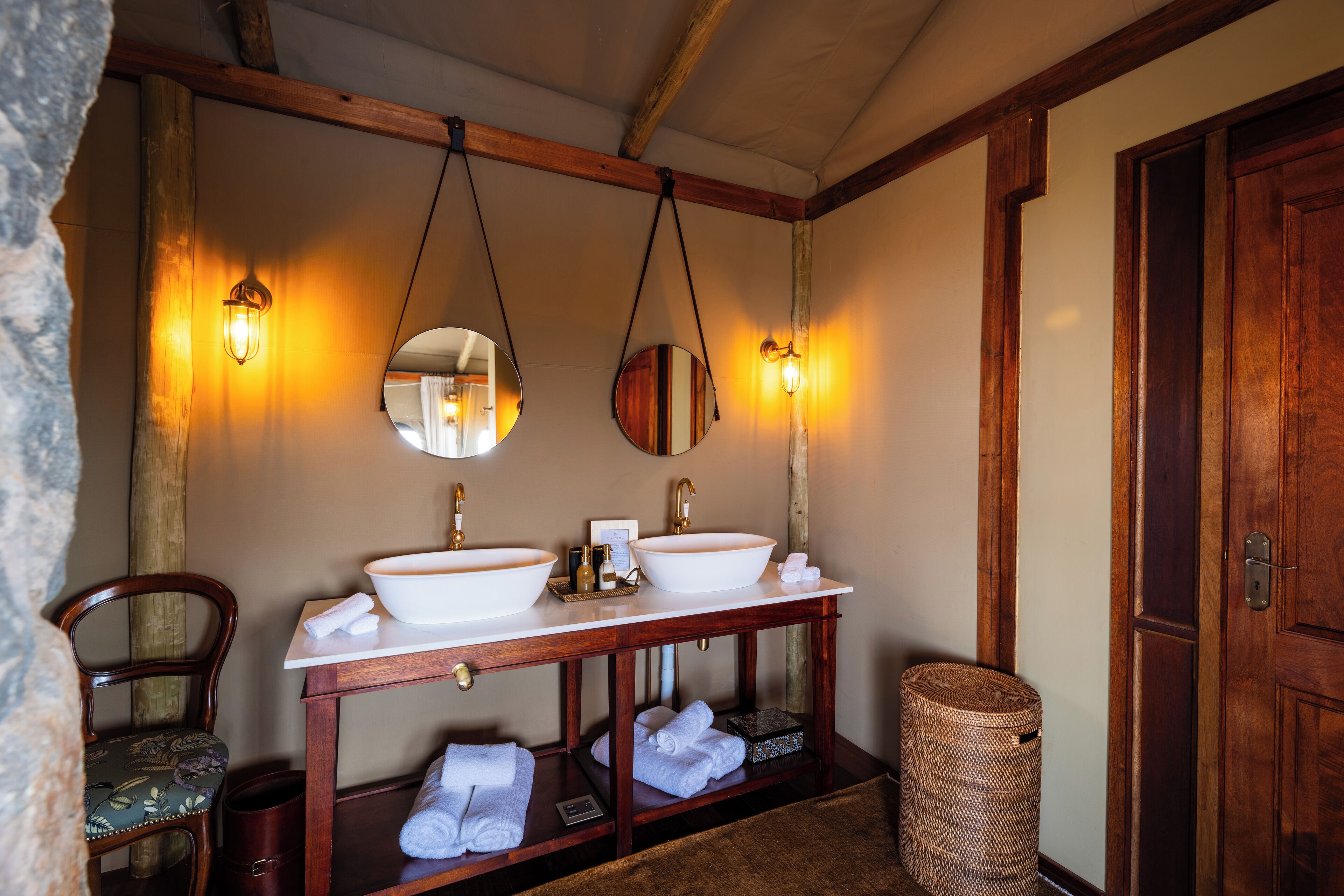 A bathroom with two sinks, a mirror, and a wooden vanity.