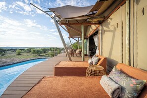 A wooden deck with a pool, outdoor seating, and a view of the landscape. - Maloba Lodge - Private Game Reserve (Tokologo)