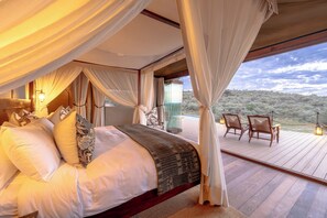 Un dormitorio con una cama grande, cortinas y vistas al exterior.