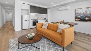 Un appartement moderne comprenant un salon, une cuisine et un coin repas.