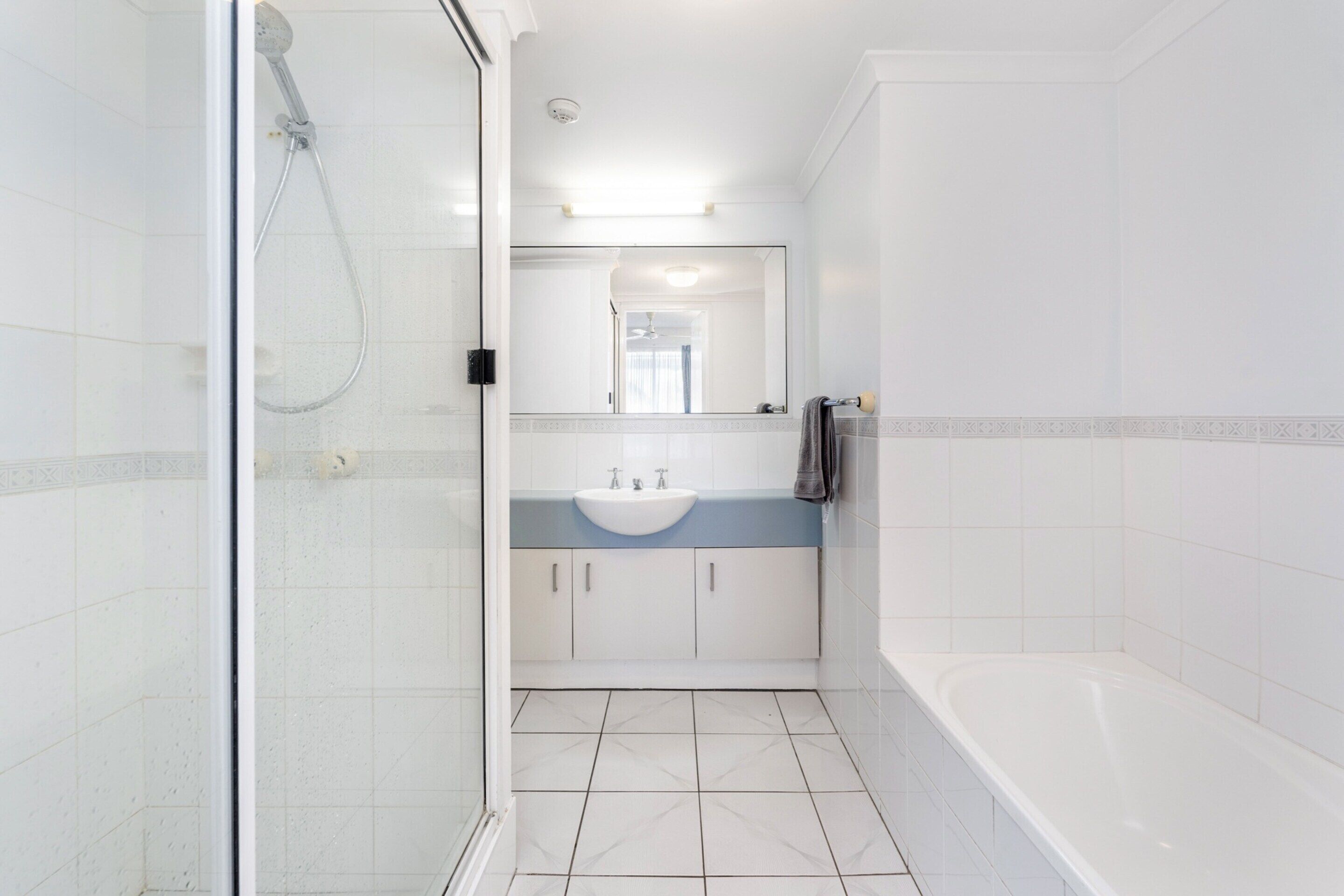 Un bagno moderno con cabina doccia in vetro, un lavandino con mobile contenitore e una vasca da bagno.