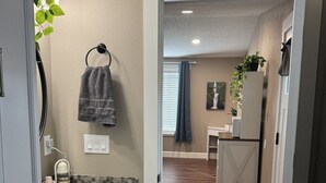 A modern kitchen with a marble countertop, a hanging towel, and a view into the dining area. - Private room and bathroom in safe Vancouver neighborhood (Vancouver)