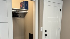 A walk-in closet with a built-in storage unit, a hanging rack, and a small safe. - Private room and bathroom in safe Vancouver neighborhood (Vancouver)
