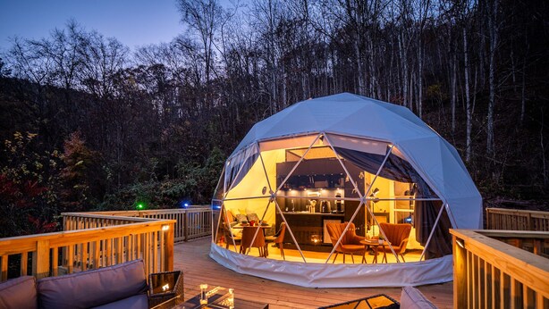 A dome-shaped tent with a bar area, wooden deck, and outdoor seating. - Romantic Geodesic Dome • Hot Tub Under the Stars (pipestem)