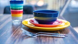 A dining table with a stack of colorful bowls and a glass of water. - Romantic Geodesic Dome • Hot Tub Under the Stars (pipestem)