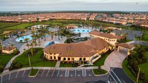 A large resort with multiple buildings, a central pool area, and a parking lot with handicapped spaces. - Ohana Memories At Championsgate (Four Corners)