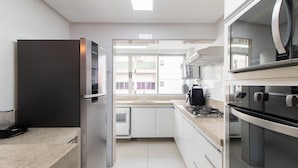 Una cocina moderna con horno empotrado, microondas y lavavajillas.