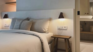 Un dormitorio moderno con una cama grande, mesitas de noche y una mesilla.