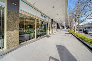 A modern building with a glass facade and a sign reading "nesuto Canberra." - Center 1-bed With Sauna, Gym, BBQ & Parking (Canberra)