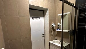 A bathroom with a toilet, sink, and glass shower enclosure. - Central Stay (İstanbul)