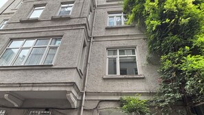 A multi-story building with a dark entrance door, a visible apartment number, and a tree growing on the side. - Central Stay (İstanbul)