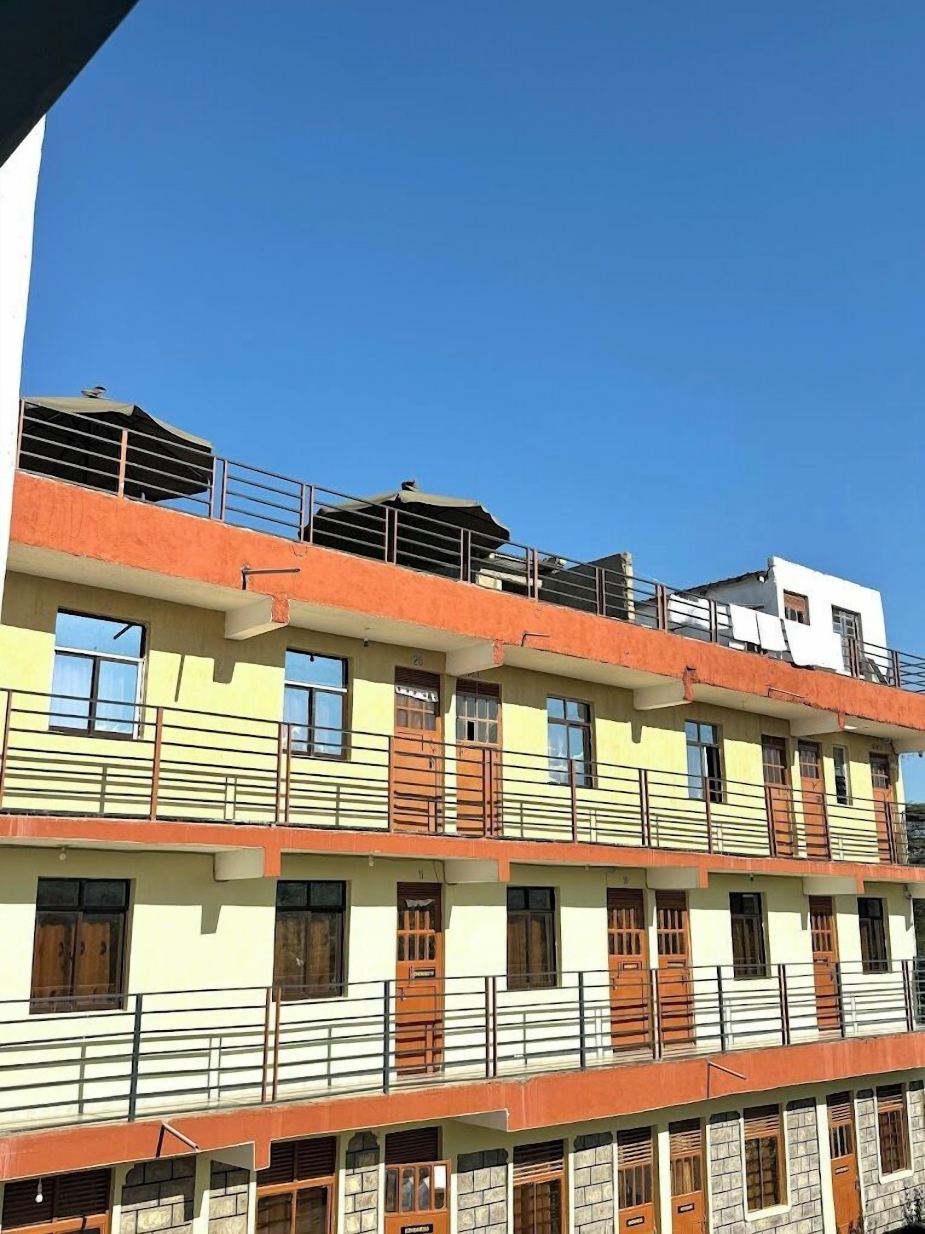 A multi-story building with balconies, windows, and a flat roof.
