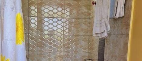 Une salle de bain avec un rideau de douche, des toilettes et un lavabo.