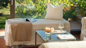 A bedroom with a bed, a bedside table with a vase and a glass of wine, and a window with a view of greenery. - House in the heart of Chianti, with 4 bedrooms, each with a private bathroom. (Toscana)