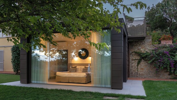 A modern outdoor living space with a glass enclosure, a sofa, and a decorative wall. - House in the heart of Chianti, with 4 bedrooms, each with a private bathroom. (Toscana)
