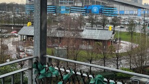 Vista d'un estadi amb un gran anunci blau i una zona coberta amb un told blau.