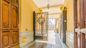 A hallway with ornate wooden doors, a wrought iron gate, and a cobblestone floor. - GuestHost - Cozy Central Apartment in Turin (Turin)