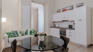A modern kitchen with white cabinets, a microwave, and a stove. - GuestHost - Cozy Central Apartment in Turin (Turin)
