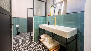 A bathroom with a white sink, a mirror, and a towel rack.
