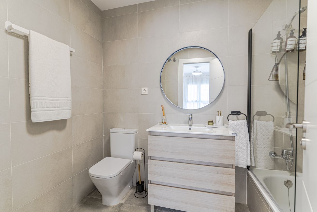 A modern bathroom with a toilet, sink, and shower.