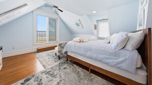 Un dormitorio con cama, ventana, ventilador de techo y decoración de estrellas.