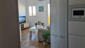 Eine moderne Küche mit integriertem Kühlschrank und einem Essbereich mit weißem Tisch und Stühlen.