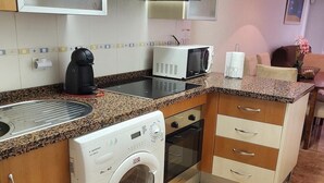 A compact kitchen with a washing machine, microwave, and oven. - Seaside apartment in Vera with terrace (vera)