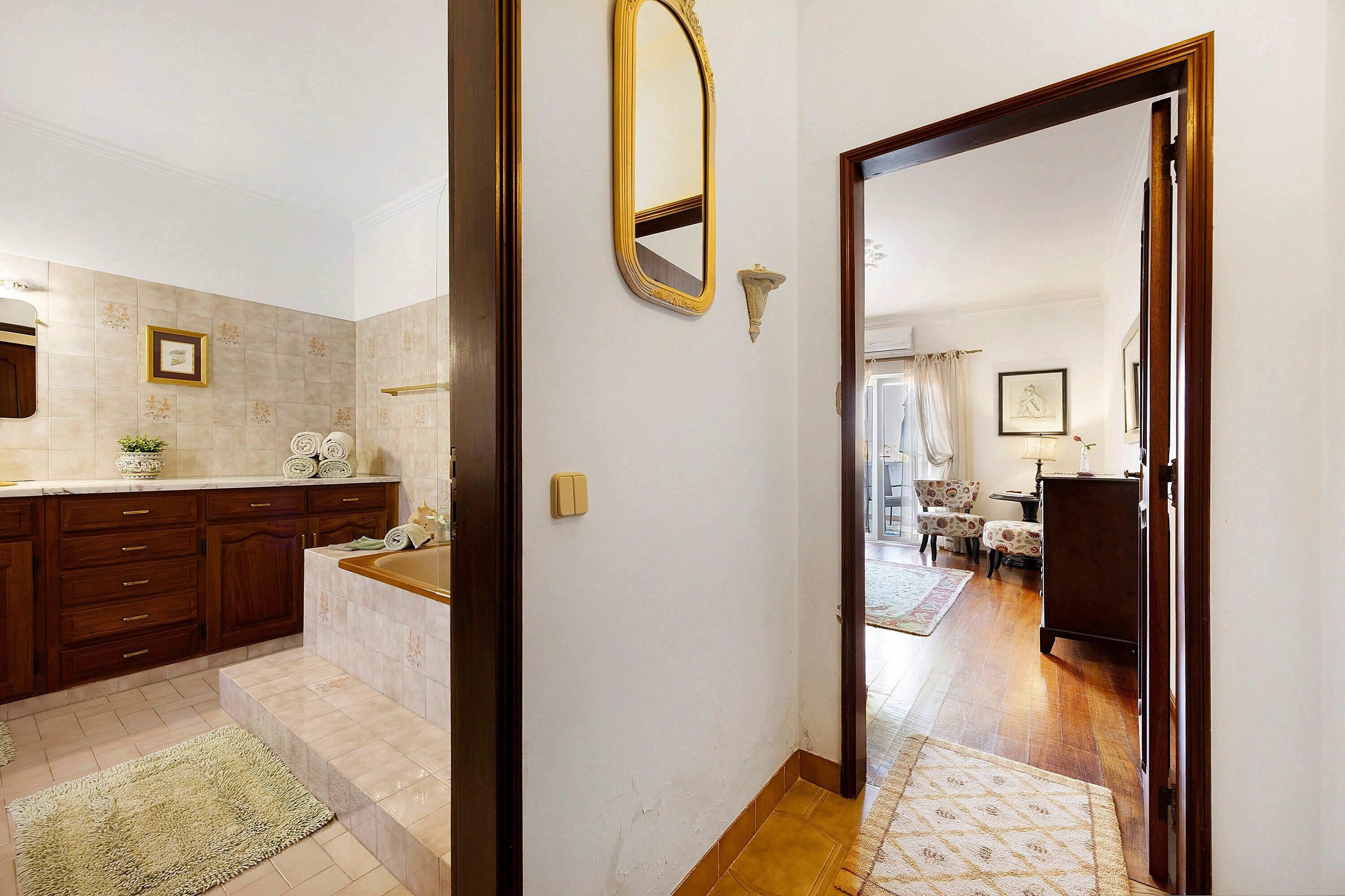 A bathroom with a bathtub, a mirror, and a towel rack.