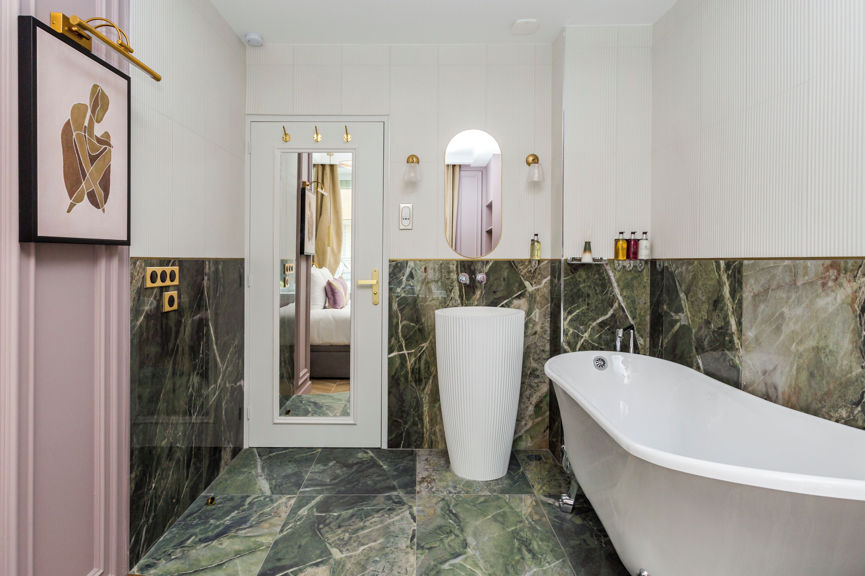 Een moderne badkamer met een vrijstaand bad, marmeren vloer en een grote spiegel.
