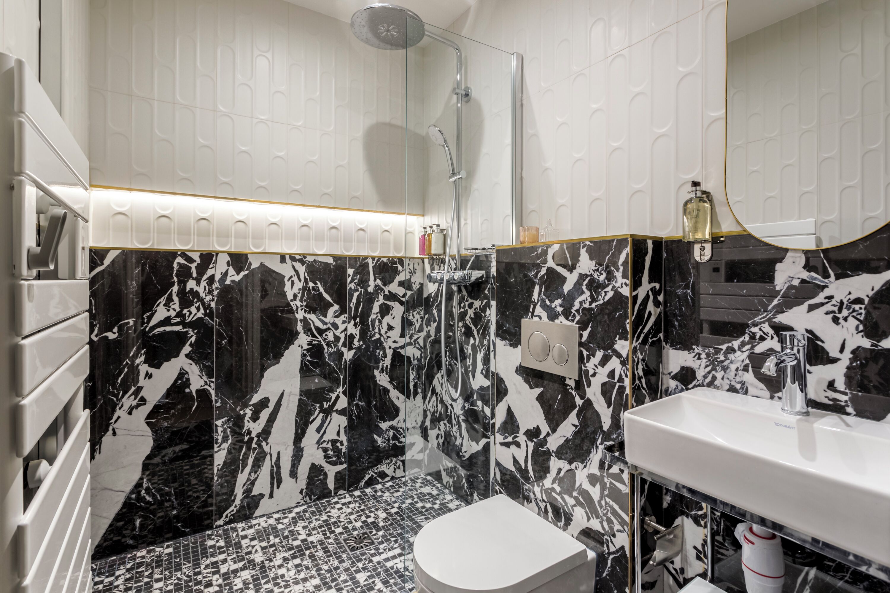 Een moderne badkamer met douche, toilet en wastafel.