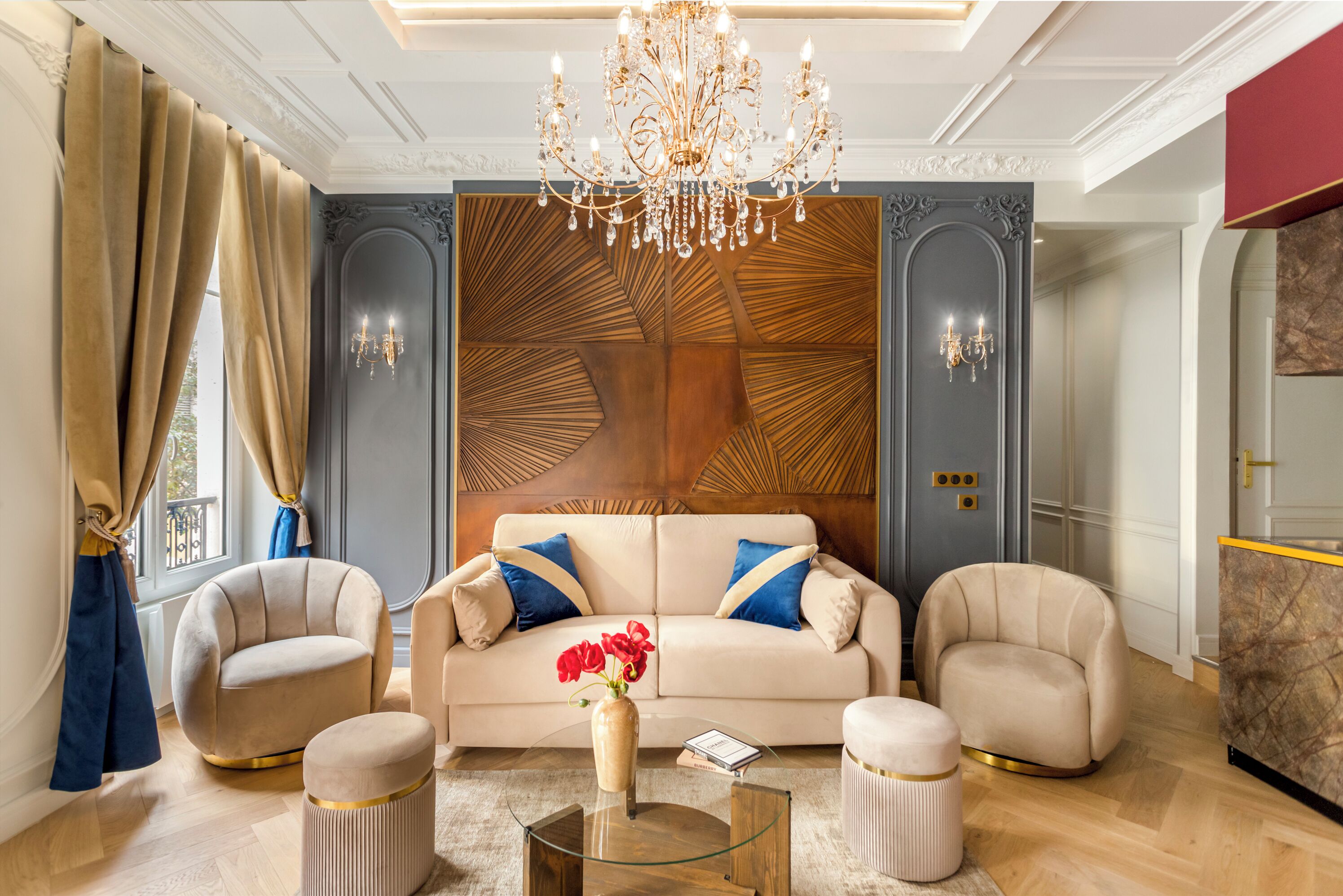 Una sala de estar lujosa con un sofá color beige, dos sillones, una mesa de centro de vidrio y un panel decorativo en la pared.