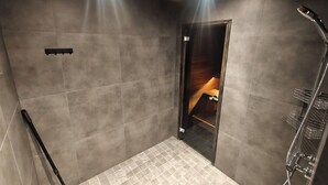 Een moderne douche ruimte met een glazen deur, een douchekop en een handdoekhouder.
