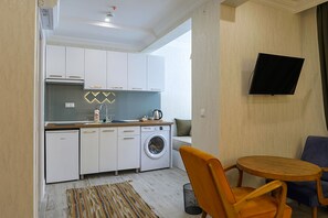 Deluxe trippelrum - utsikt mot trädgården | Värdeförvaringsskåp på rummet, skrivbord och mörkläggningsgardiner