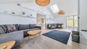 A spacious living area with a high ceiling, a large window, and a modern design.