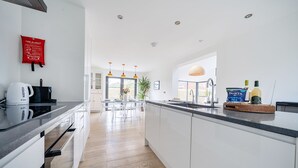 A modern kitchen with white cabinets, a black countertop, and a central island.