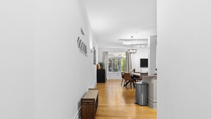 A modern kitchen with a dining area, wooden flooring, and a view of the outdoors. - Cozy Studio Near Plaza+Uptown (Charlotte)