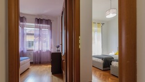 Une chambre avec un lit, un bureau et une fenêtre avec des rideaux.