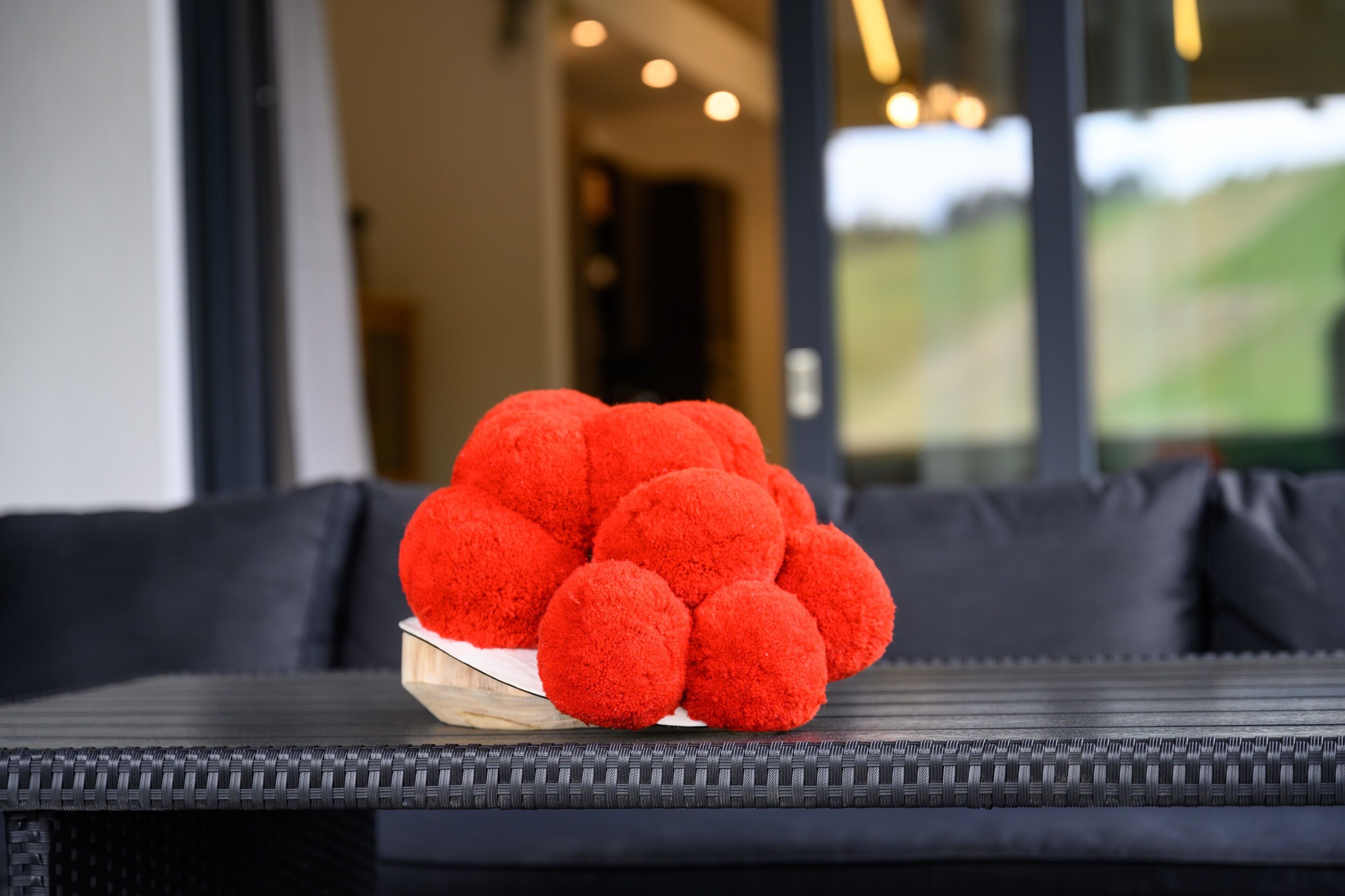 Un sofà de vimetes amb un bol de boles vermelles.
