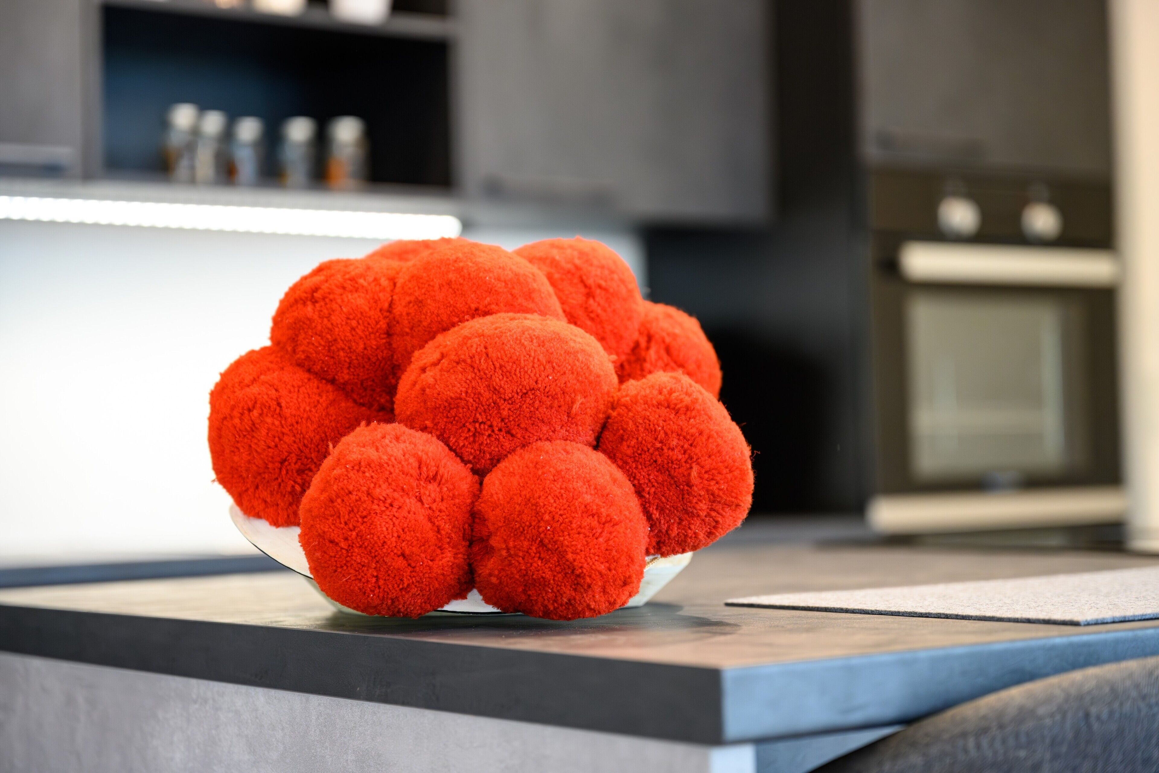 A bowl of round, orange objects on a countertop.