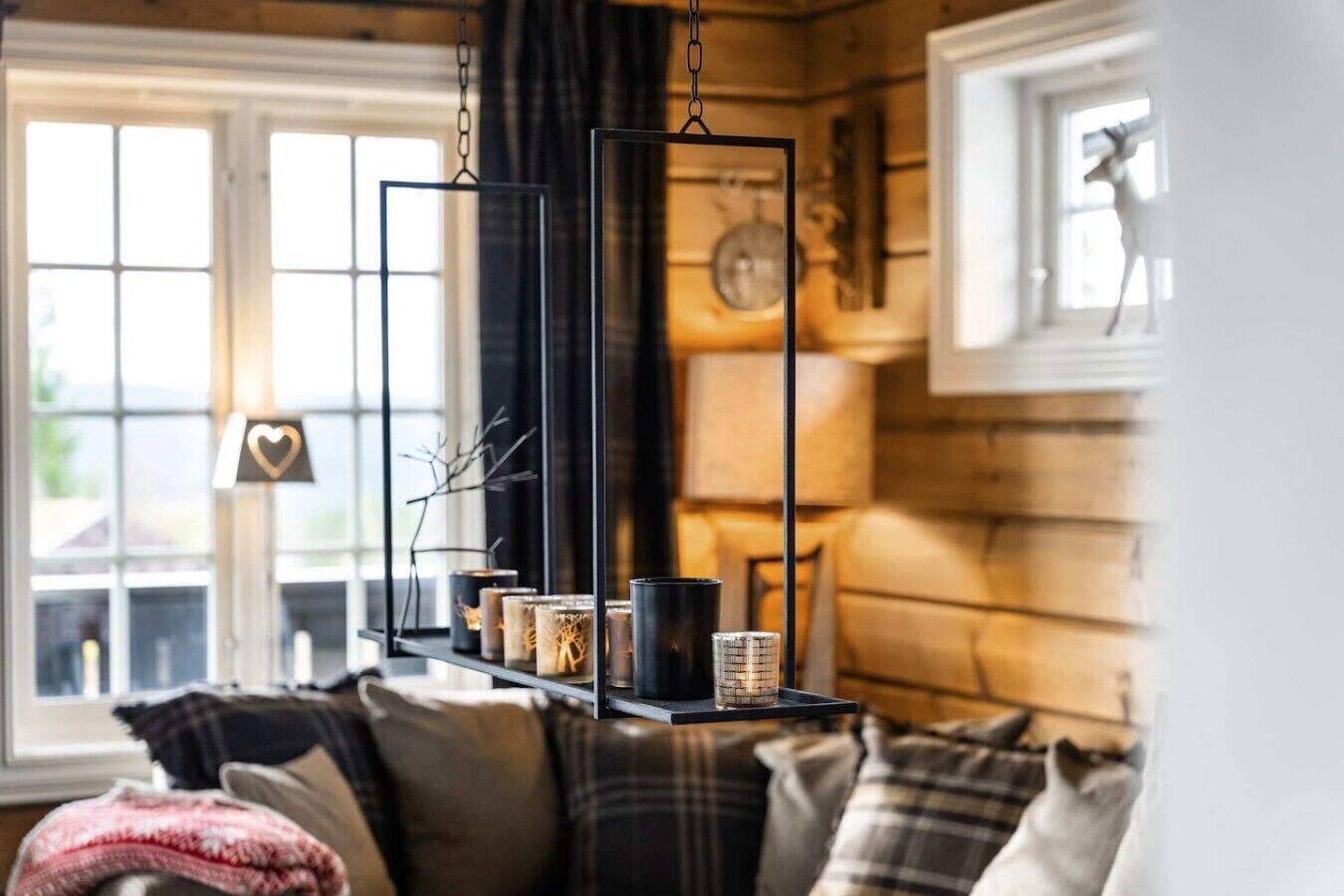 Una sala acogedora con chimenea, un sofá y una lámpara colgante.